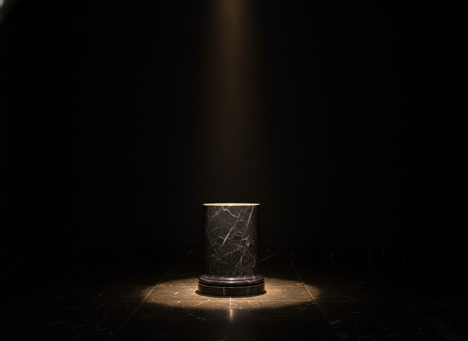 A sculpture on a stone plinth in a sunlit gallery, a small label mounted beside it
